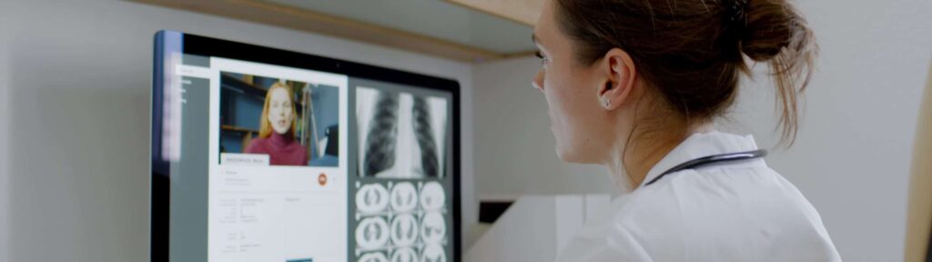 Doctor looking at x-rays on a desktop computer