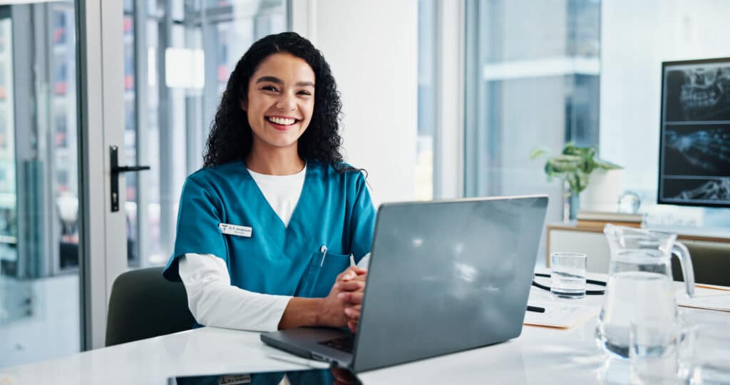 Happy woman, portrait or nurse with laptop for medical research, planning or diagnosis at hospital. Email, female person or healthcare worker with smile, computer or assistance for health development.
