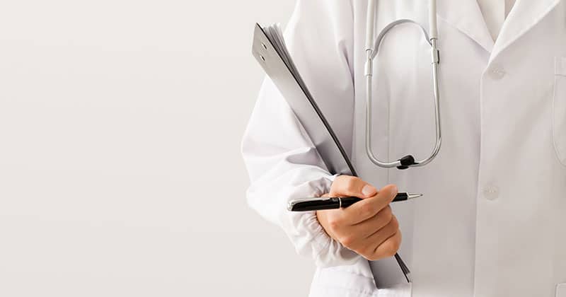 Healthcare professional reviewing patient charts for charge capture